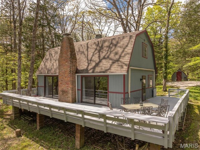 87 E Altdorf Dr, Innsbrook, MO 63390 - back of property with a wooden deck, a shingled roof, a chimney, and outdoor dining space