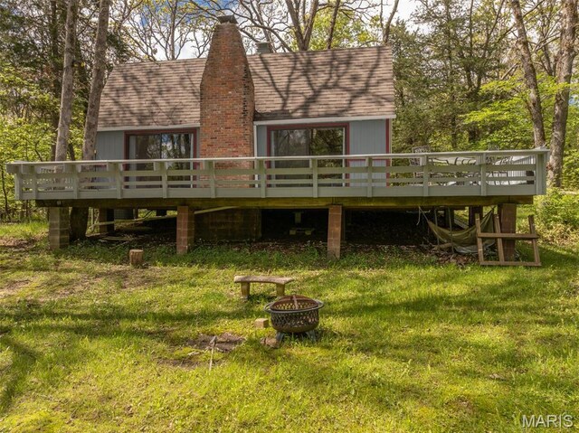 87 E Altdorf Dr, Innsbrook, MO 63390 - back of property featuring a fire pit, a deck, roof with shingles, and a lawn