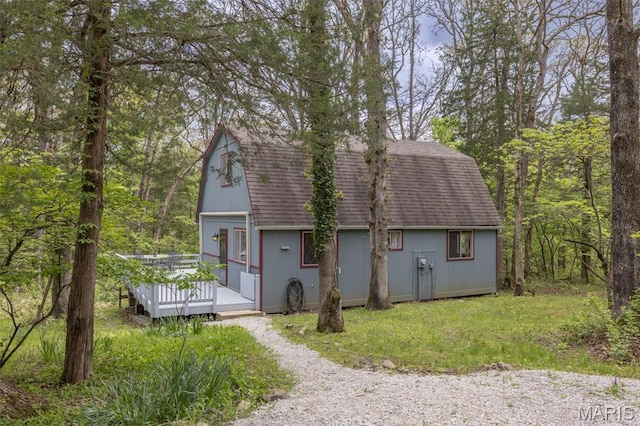 87 E Altdorf Dr, Innsbrook, MO 63390 - view of front of property featuring a wooden deck, gravel driveway, a gambrel roof, and a shingled roof