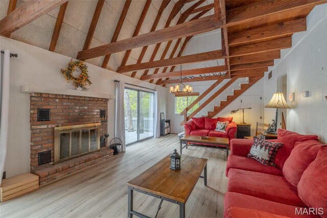 87 E Altdorf Dr, Innsbrook, MO 63390 - living room featuring stairs, wood finished floors, a brick fireplace, high vaulted ceiling, and a chandelier