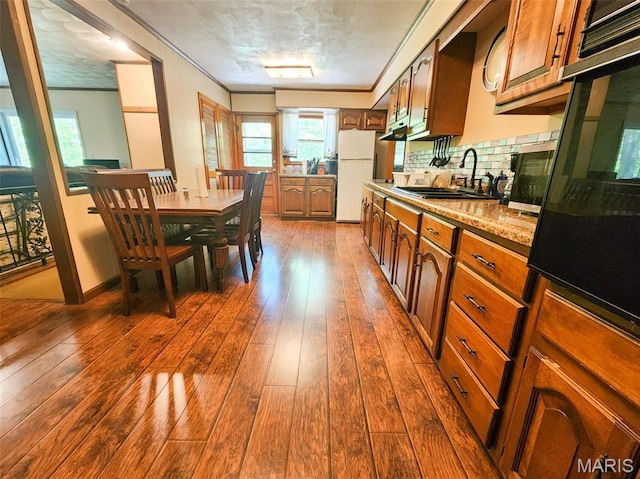 15222 Circle Dr, Gillespie, IL 62033 - kitchen with freestanding refrigerator, a sink, dark wood finished floors, brown cabinetry, and backsplash