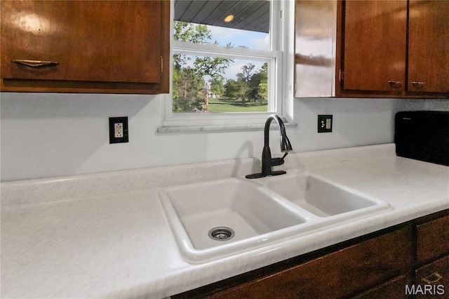 4900 Eiffel Dr, Godfrey, IL 62035 - kitchen view of a sink, light countertops, and dark brown cabinetry