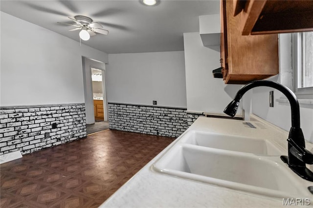 4900 Eiffel Dr, Godfrey, IL 62035 - kitchen with a sink, a wainscoted wall, a ceiling fan, and brown cabinetry
