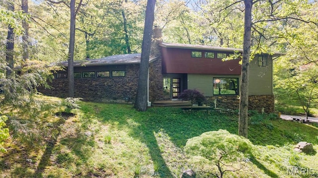 view of front of house featuring a front lawn and stone siding