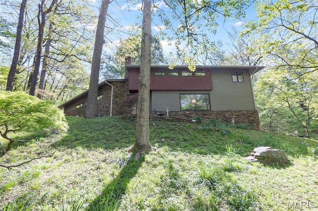 view of property exterior with a chimney and brick siding