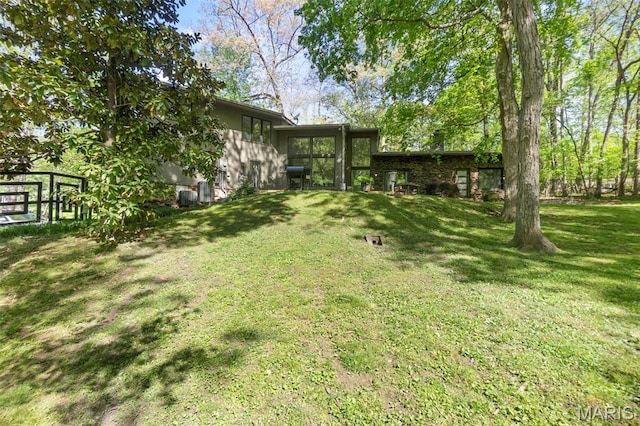 view of green lawn featuring a sunroom