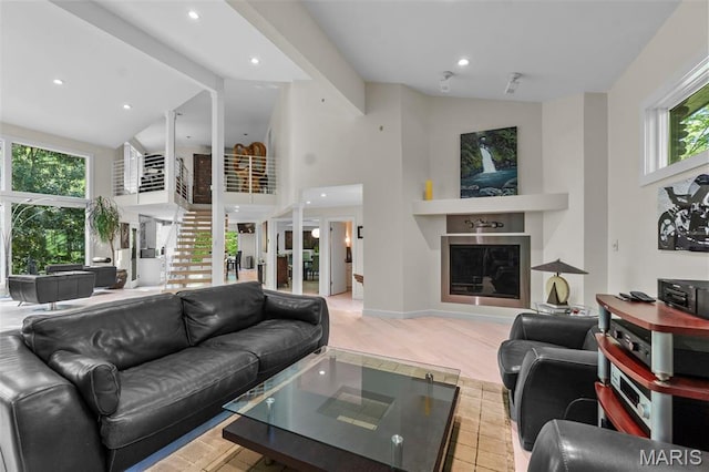living area featuring high vaulted ceiling, a fireplace, light wood finished floors, beamed ceiling, and recessed lighting