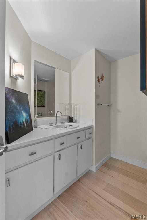 bathroom featuring wood finished floors, baseboards, and vanity