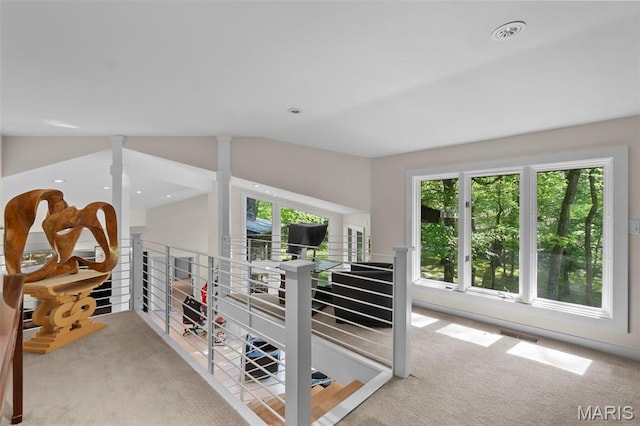 hall featuring carpet, healthy amount of natural light, and lofted ceiling
