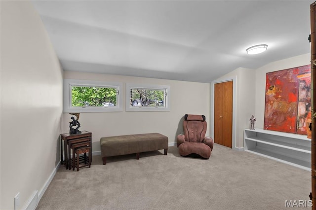 sitting room featuring carpet flooring, vaulted ceiling, and baseboards