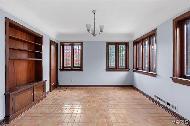 7280 S Roland Blvd, Saint Louis, MO 63121 - unfurnished dining area with built in shelves, a chandelier, and baseboards