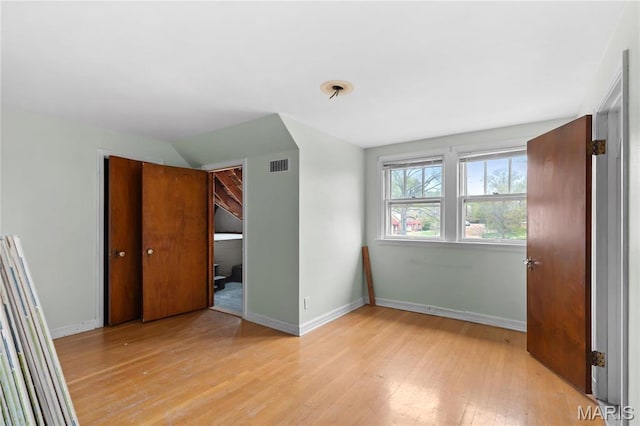 7280 S Roland Blvd, Saint Louis, MO 63121 - unfurnished bedroom featuring light wood finished floors, baseboards, a closet, and vaulted ceiling