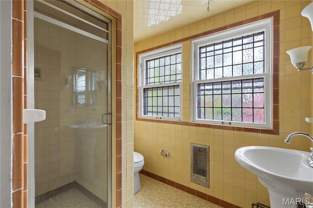 7280 S Roland Blvd, Saint Louis, MO 63121 - bathroom with tile walls, a stall shower, a sink, tile patterned flooring, and toilet