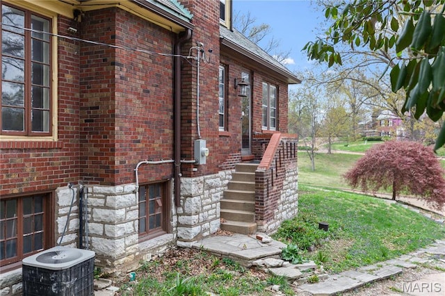 7280 S Roland Blvd, Saint Louis, MO 63121 - view of side of home with brick siding, central AC, and stairway