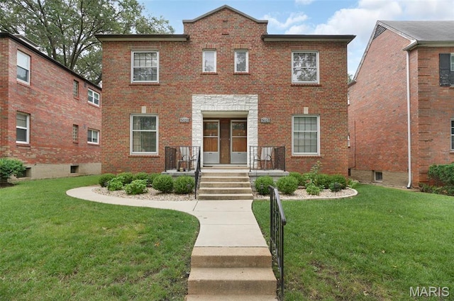 view of front of home featuring brick siding and a front yard