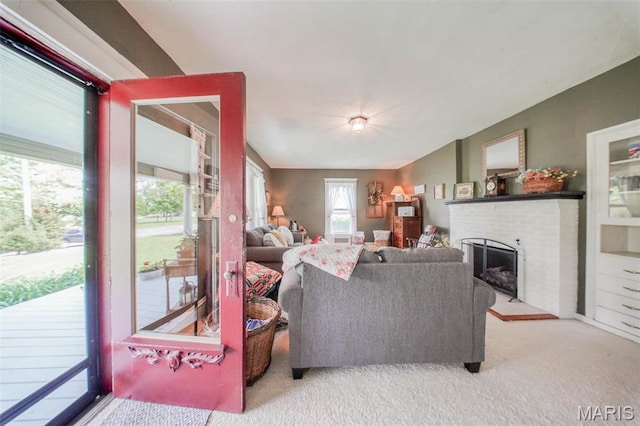 carpeted living area with a brick fireplace