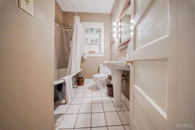 bathroom featuring toilet, a shower with curtain, and tile patterned floors