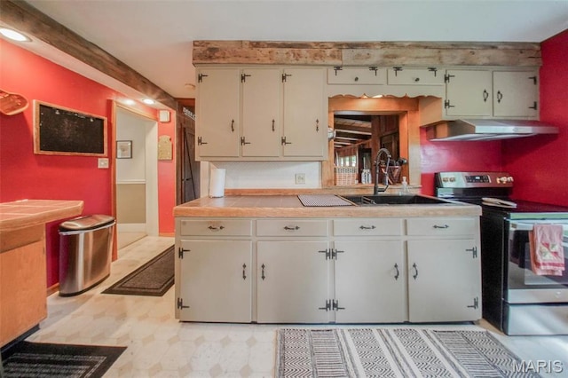 kitchen featuring stainless steel electric range oven, under cabinet range hood, a sink, tile countertops, and light floors