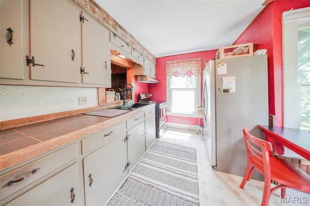 kitchen featuring appliances with stainless steel finishes, a sink, under cabinet range hood, and white cabinets