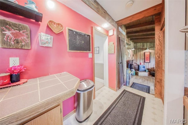 bathroom with tile patterned floors and beamed ceiling