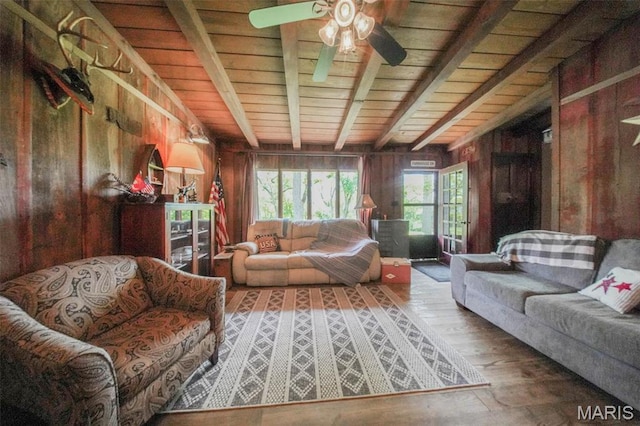 living area featuring wood walls, wood ceiling, wood-type flooring, and a ceiling fan