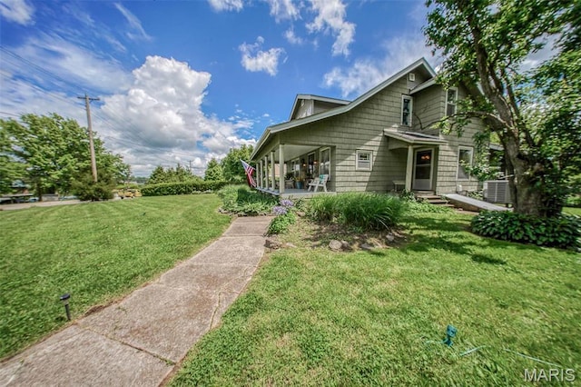 view of front of property featuring a front yard and central AC unit