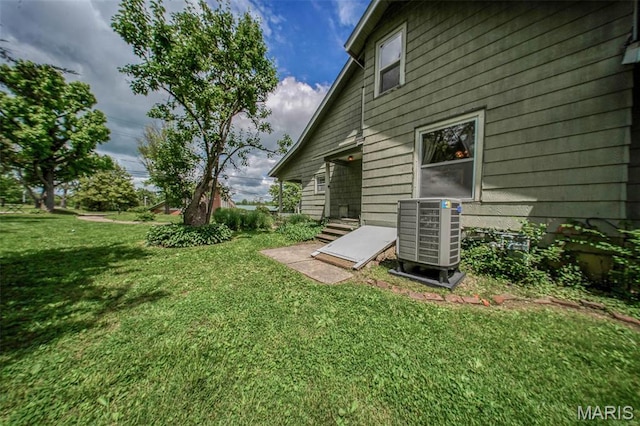 view of grassy yard featuring central air condition unit
