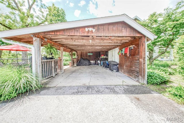 view of parking / parking lot with a carport and fence