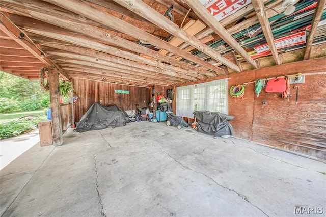 misc room featuring unfinished concrete floors and a garage