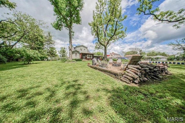 view of grassy yard featuring a fire pit