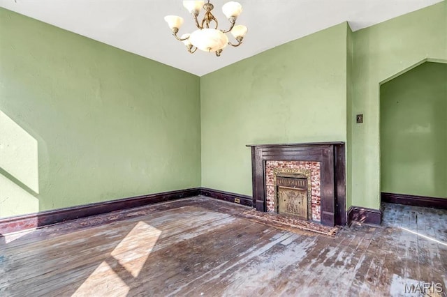 1041 Garth Ave, Saint Louis, MO 63147 - unfurnished living room featuring a chandelier, wood-type flooring, a fireplace, and baseboards