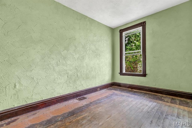 1041 Garth Ave, Saint Louis, MO 63147 - spare room with hardwood / wood-style flooring, baseboards, and a textured wall