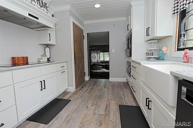 2754 Adeline Ave, Cape Girardeau, MO 63701 - kitchen with premium range hood, black electric cooktop, light countertops, light wood-style floors, and ornamental molding