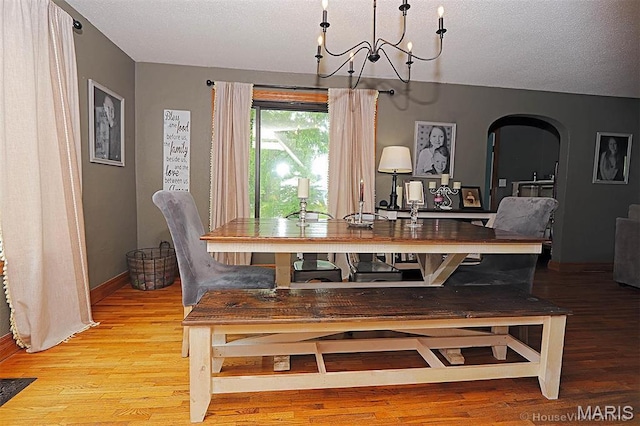 2754 Adeline Ave, Cape Girardeau, MO 63701 - dining area featuring a chandelier, light wood-style floors, arched walkways, and a textured ceiling