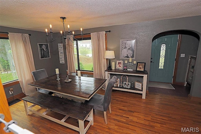 2754 Adeline Ave, Cape Girardeau, MO 63701 - dining area with arched walkways, wood finished floors, a textured wall, a textured ceiling, and a chandelier