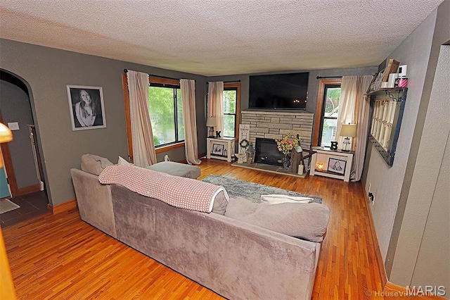 2754 Adeline Ave, Cape Girardeau, MO 63701 - living area featuring wood finished floors, a fireplace, a textured ceiling, and a textured wall