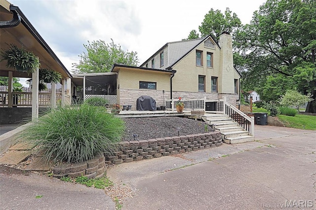 2754 Adeline Ave, Cape Girardeau, MO 63701 - view of front of home with a sunroom, a chimney, and stone siding