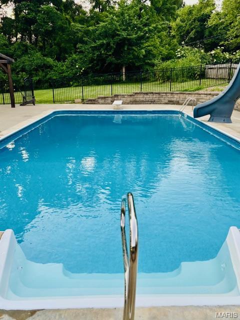 2754 Adeline Ave, Cape Girardeau, MO 63701 - view of pool with a water slide, a fenced backyard, view of scattered trees, and a diving board