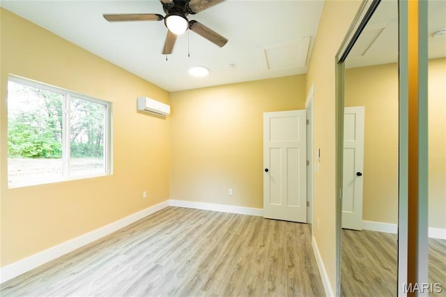 408 E Roosevelt, Salem, MO 65560 - unfurnished room with a wall unit AC, light wood-type flooring, a ceiling fan, baseboards, and attic access
