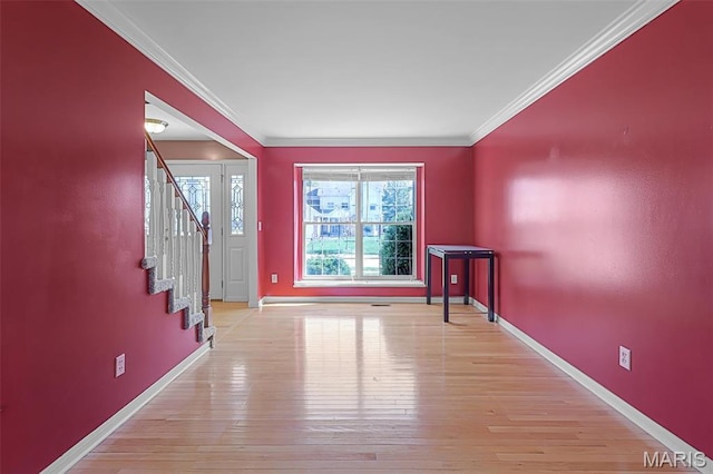 foyer featuring baseboards, light wood-style floors, stairway, and ornamental molding