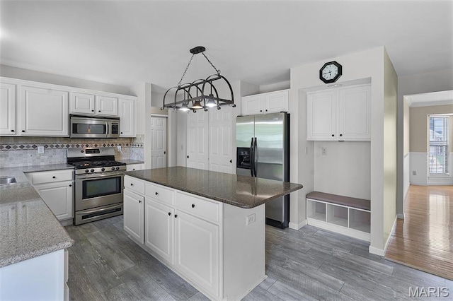 kitchen featuring appliances with stainless steel finishes, a chandelier, and white cabinets