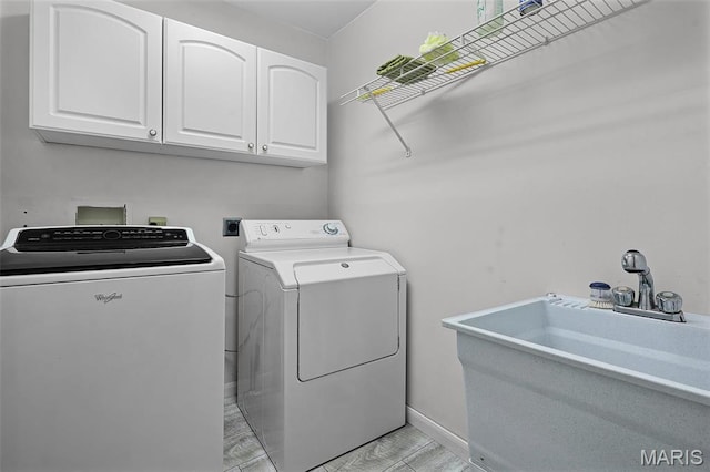 laundry room featuring cabinet space, washing machine and dryer, and baseboards