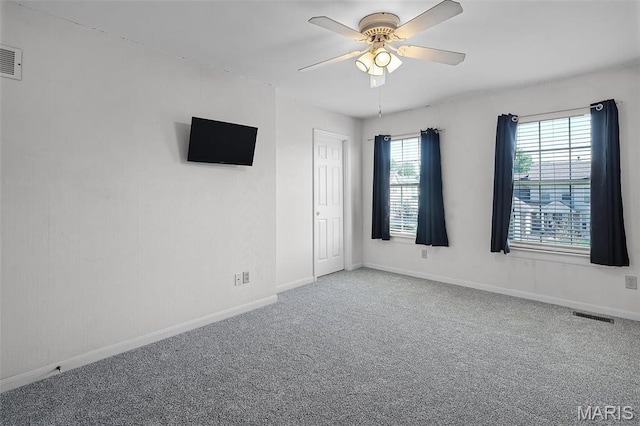 carpeted spare room with baseboards and a ceiling fan