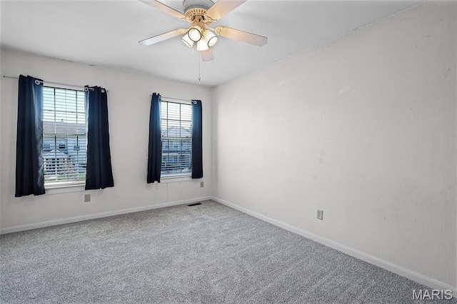 empty room with carpet flooring, baseboards, and a ceiling fan
