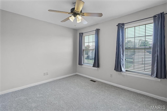 carpeted spare room with baseboards and a ceiling fan