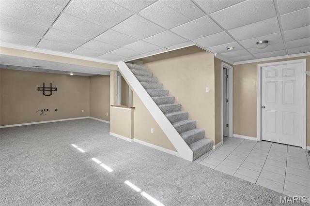 finished basement featuring stairway, baseboards, carpet flooring, a paneled ceiling, and ornamental molding