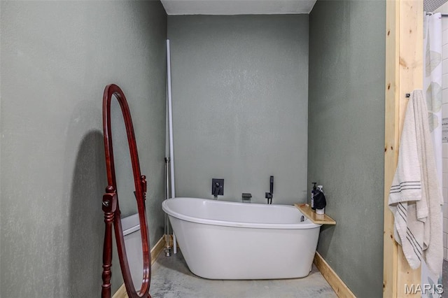 22950 Pin Oak Dr, Lebanon, MO 65536 - full bathroom featuring a freestanding tub, baseboards, and concrete floors