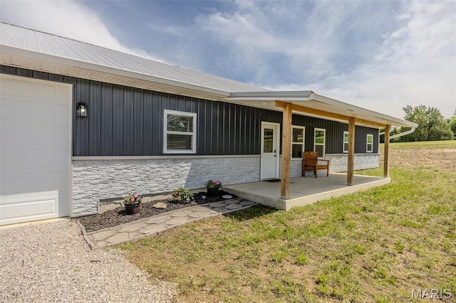 22950 Pin Oak Dr, Lebanon, MO 65536 - entrance to property with stone siding, covered porch, a lawn, and board and batten siding