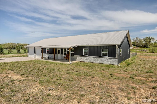 22950 Pin Oak Dr, Lebanon, MO 65536 - view of front of property with stone siding, a patio area, metal roof, and board and batten siding