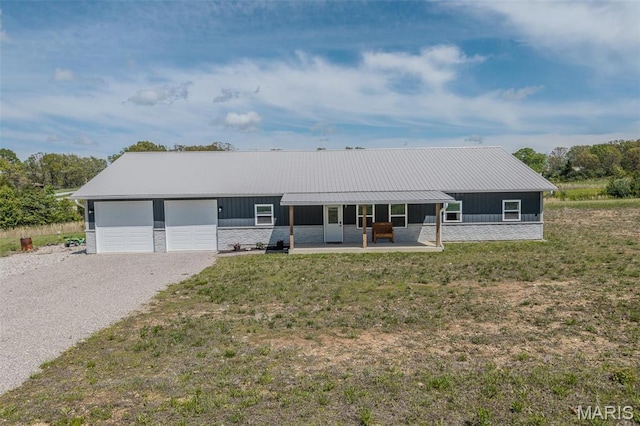 22950 Pin Oak Dr, Lebanon, MO 65536 - ranch-style home with driveway, a garage, stone siding, a front lawn, and metal roof